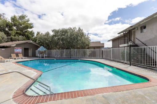 a swimming pool with a fence around it next to a building